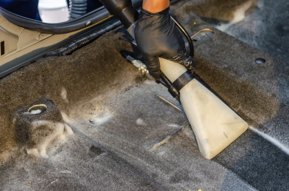 Teppich im Fußraum wird mit Sprühextraktion gereinigt